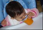 Bébé essaie de manger un pot avec le couvercle